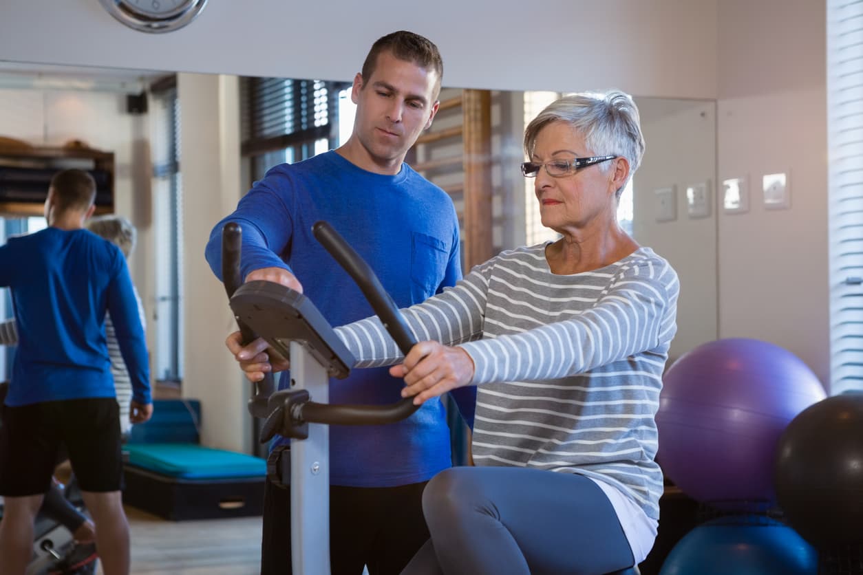 Physiotherapist showing workout record on exercise bike